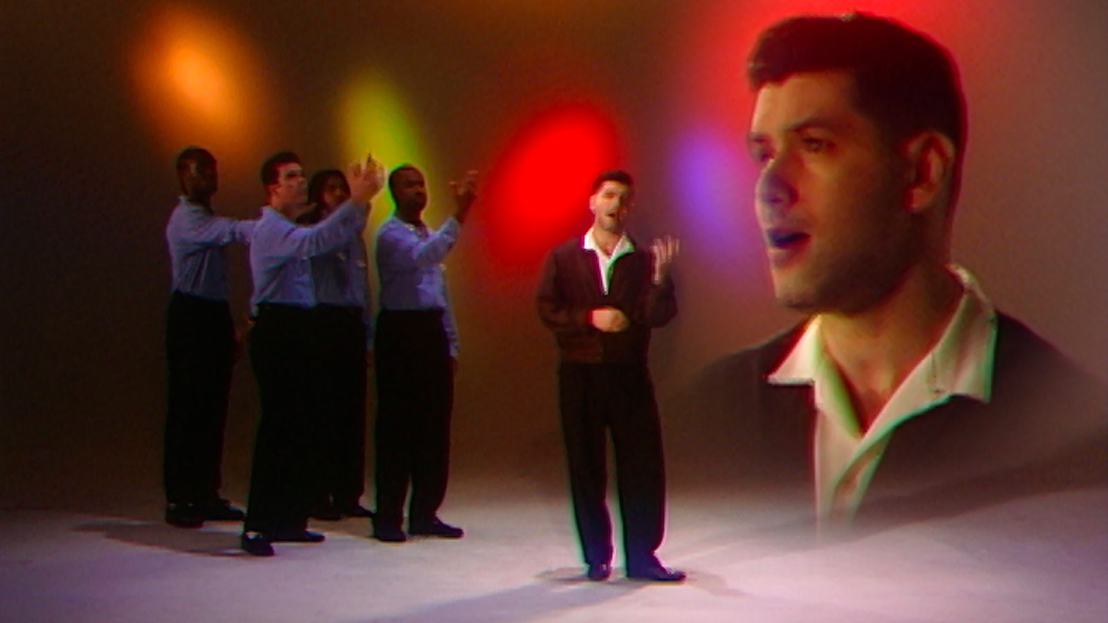 Aaron surrounded by backupdancers on the left and a floating enlargement of his head on the right.